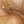 The painting “Warmth Whirlwind” is a textured abstraction in golden-copper tones.