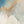 The painting “Dawn in the Clouds” depicts dawn over mountain peaks in shades of blue and gold