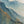 The painting “Dawn in the Clouds” depicts dawn over mountain peaks in shades of blue and gold