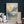 The painting “Dawn in the Clouds” depicts dawn over mountain peaks in shades of blue and gold