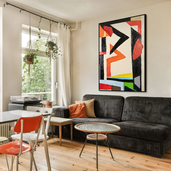 The painting "Architecture of Movement" is a bright geometric abstraction in red and black tones.