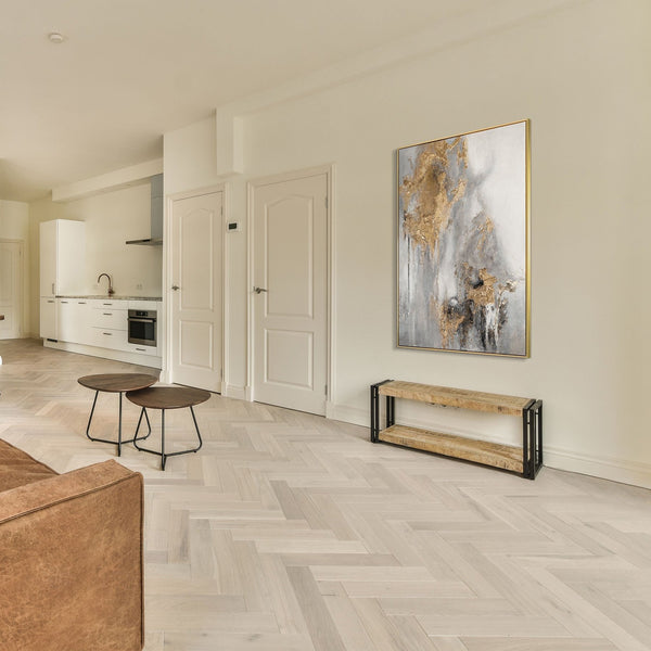 The painting "Breath of Stone" is a vertical abstraction in gray-gold tones.